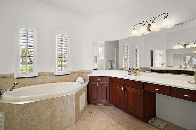 bathroom featuring a bath, vanity, visible vents, and tile patterned floors