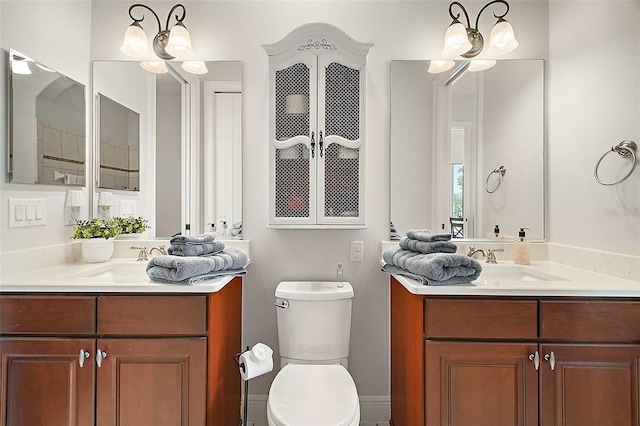 full bathroom featuring two vanities, a sink, and toilet