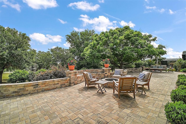 view of patio with an outdoor living space with a fire pit