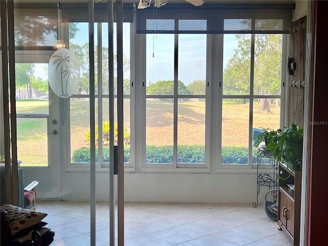 doorway to outside featuring light tile patterned floors and a ceiling fan