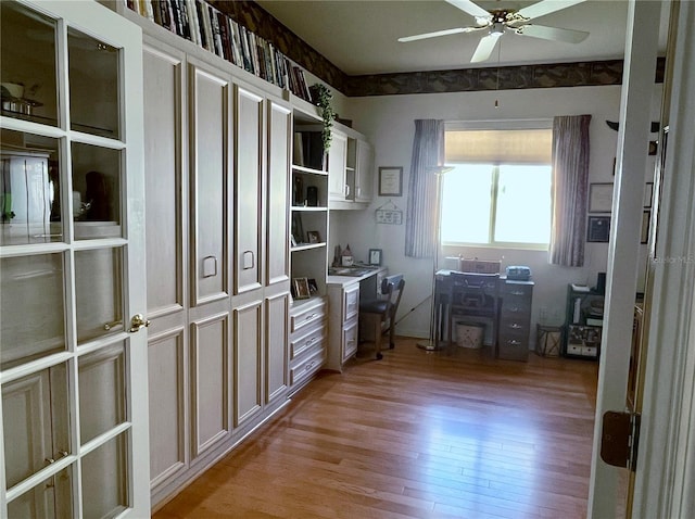 office with light wood-type flooring and ceiling fan