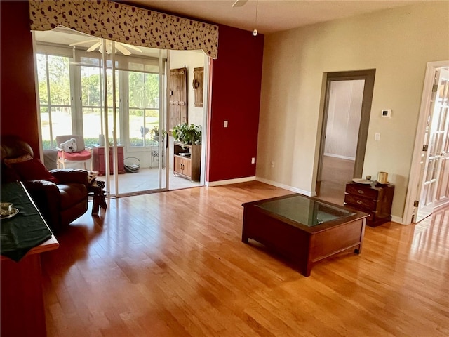 living room with ceiling fan, wood finished floors, and baseboards