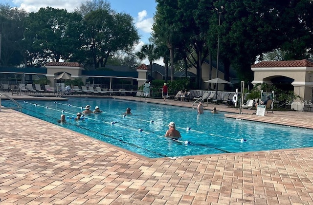 community pool featuring fence and a patio