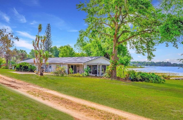 single story home featuring a water view and a front lawn