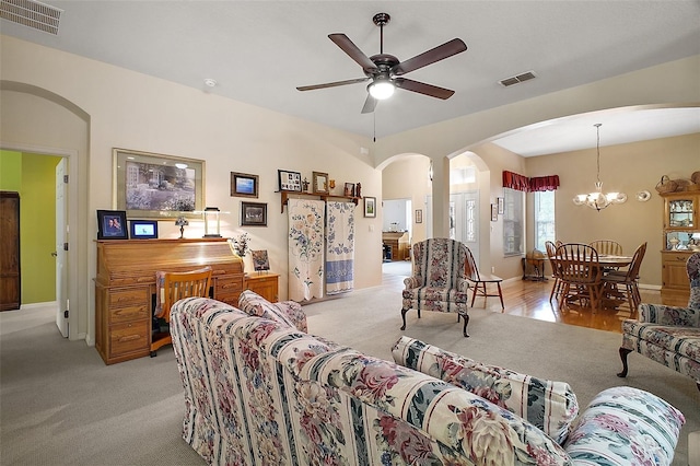 3828 Arbordale Ct, Leesburg, FL 34748 - carpeted living area featuring visible vents, baseboards, arched walkways, and ceiling fan with notable chandelier