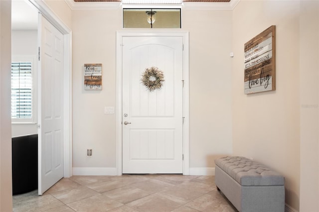 foyer entrance featuring light tile patterned floors, baseboards, and ornamental molding