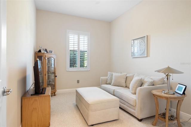 living area featuring baseboards and light colored carpet