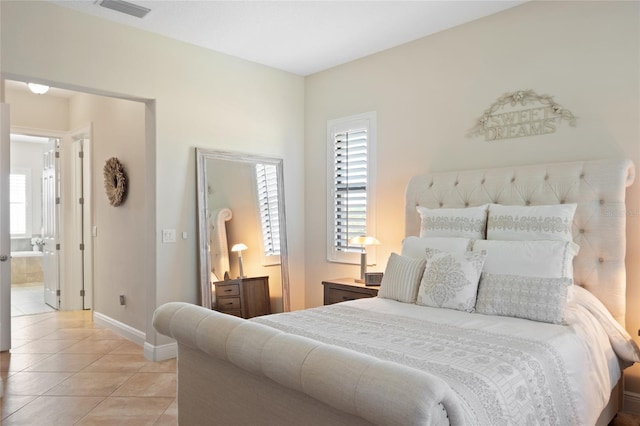 bedroom with light tile patterned floors, baseboards, connected bathroom, and visible vents