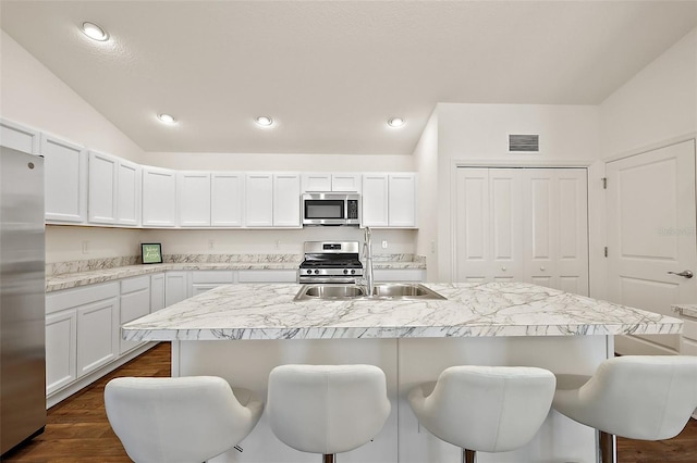 6248 Siverson Ter, The Villages, FL 32163 - kitchen with visible vents, a breakfast bar, dark wood-style floors, light countertops, and appliances with stainless steel finishes