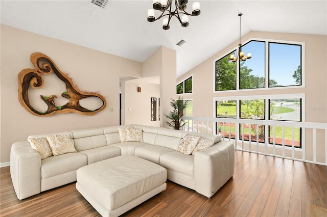 living area with an inviting chandelier, wood finished floors, and high vaulted ceiling
