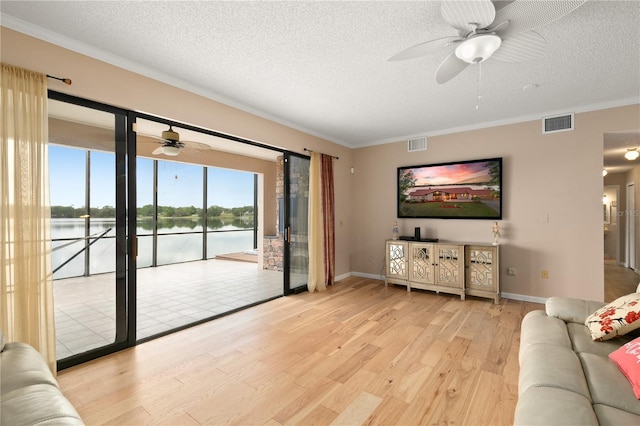 living room with a ceiling fan, a textured ceiling, and visible vents