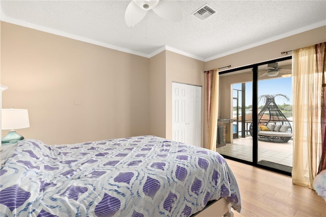 bedroom featuring visible vents, crown molding, access to exterior, light wood-type flooring, and a textured ceiling
