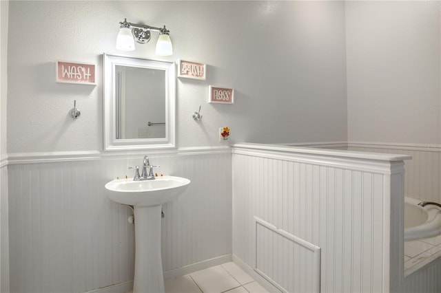bathroom featuring a sink, wainscoting, and tile patterned floors