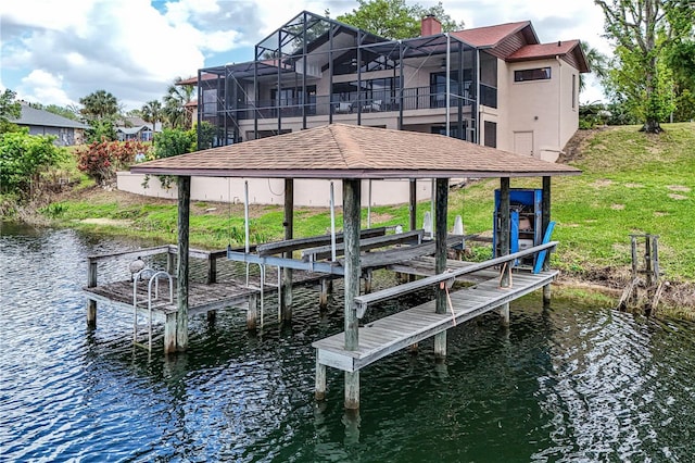 dock area with boat lift, a water view, and a yard