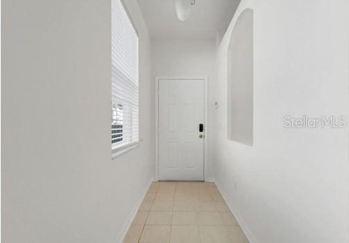 9081 Saint Andrews Way, Mount Dora, FL 32757 - corridor with arched walkways, baseboards, and light tile patterned floors