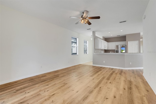 9081 Saint Andrews Way, Mount Dora, FL 32757 - unfurnished living room with light wood-type flooring, a ceiling fan, baseboards, and recessed lighting