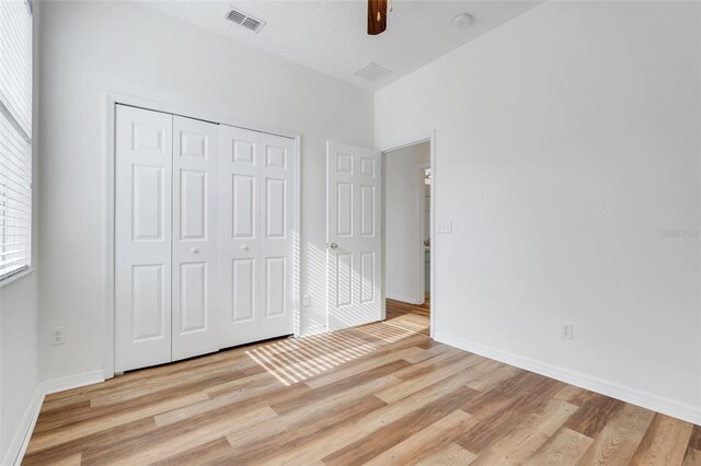 9081 Saint Andrews Way, Mount Dora, FL 32757 - unfurnished bedroom featuring light wood-style floors, a closet, baseboards, and a ceiling fan