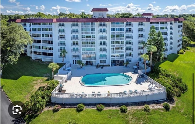 view of subject property featuring apartment complex and a pool