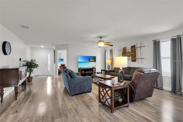 living area with visible vents, baseboards, and light wood-type flooring