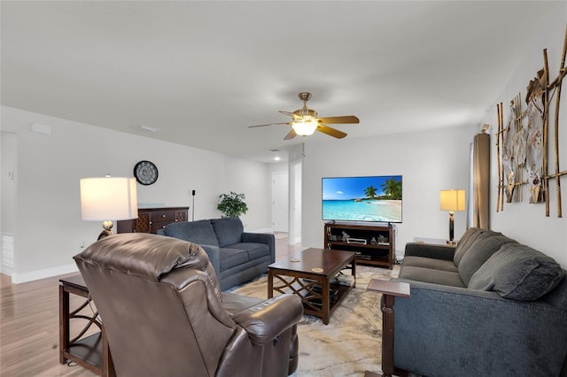 living area featuring light wood-style flooring, ceiling fan, and baseboards