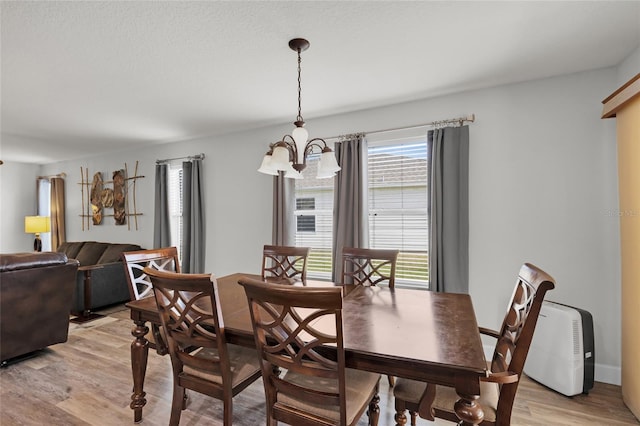 dining room featuring light wood finished floors and a notable chandelier