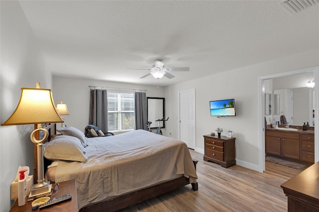 bedroom featuring connected bathroom, a ceiling fan, visible vents, light wood finished floors, and baseboards