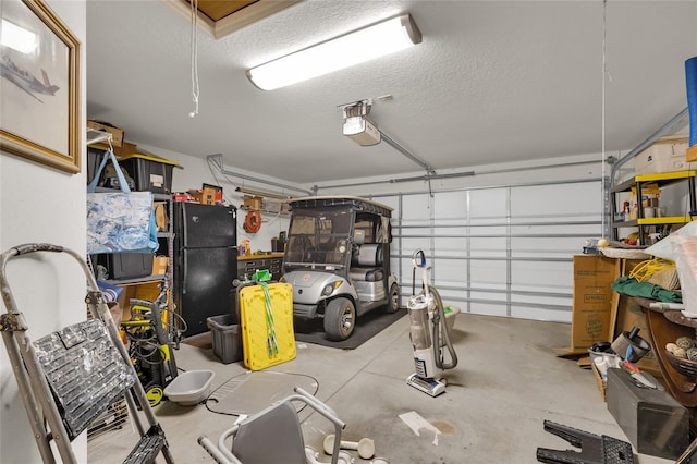 garage featuring a garage door opener and freestanding refrigerator