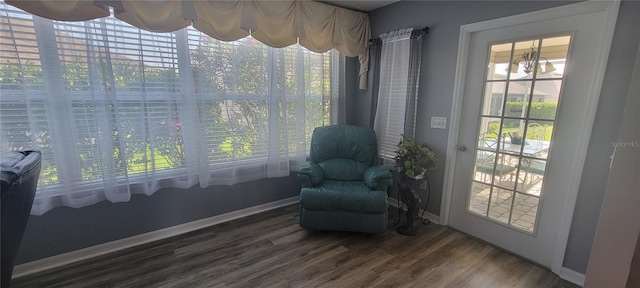 living area with baseboards and wood finished floors