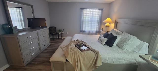 bedroom with dark wood-type flooring and baseboards