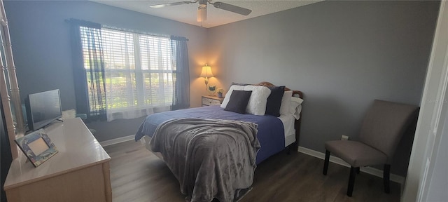 bedroom featuring multiple windows, baseboards, and wood finished floors