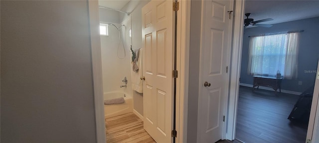 corridor with wood finished floors and baseboards