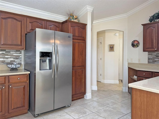 3325 Archer Ave, The Villages, FL 32162 - kitchen featuring stainless steel refrigerator with ice dispenser, arched walkways, decorative backsplash, ornamental molding, and light countertops