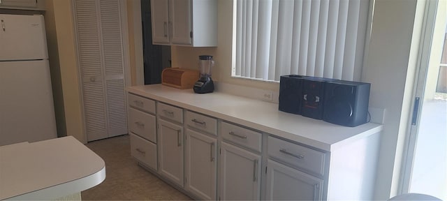 2855 Picadilly Cir, Kissimmee, FL 34747 - kitchen featuring light countertops, freestanding refrigerator, and white cabinetry