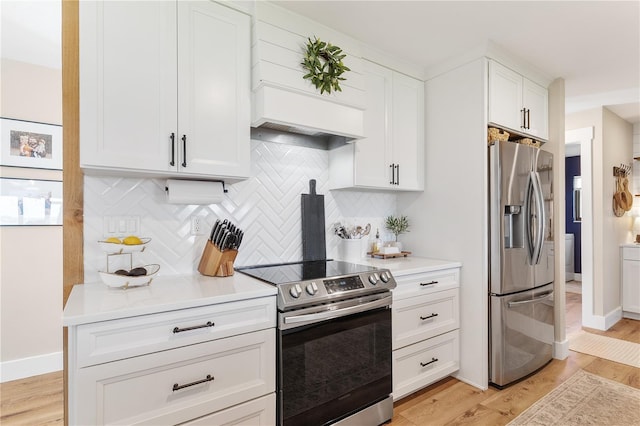 kitchen featuring light wood-type flooring, light countertops, backsplash, and appliances with stainless steel finishes