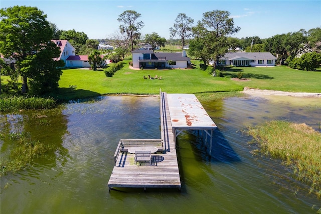 view of dock with a water view and a yard