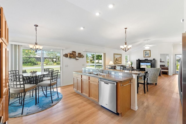 kitchen with light wood-style flooring, stainless steel appliances, a center island with sink, and a sink