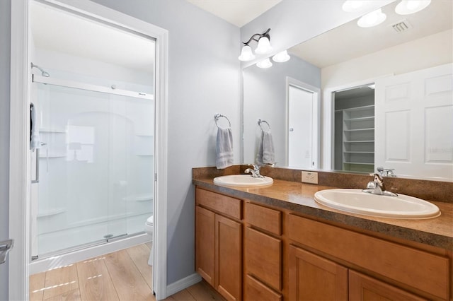 bathroom featuring a shower stall, visible vents, toilet, and a sink