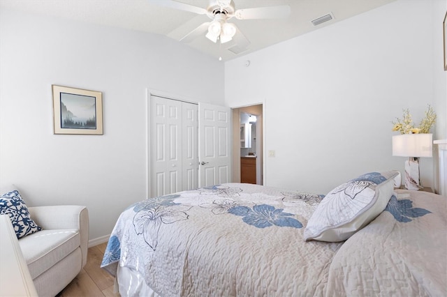 bedroom with lofted ceiling, visible vents, light wood-style floors, a closet, and ceiling fan