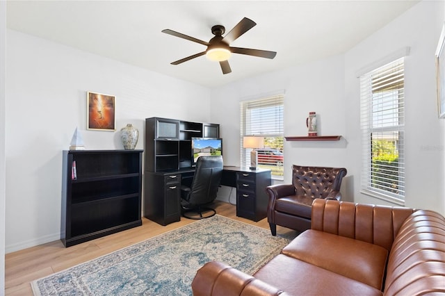 office featuring light wood-type flooring, baseboards, and ceiling fan