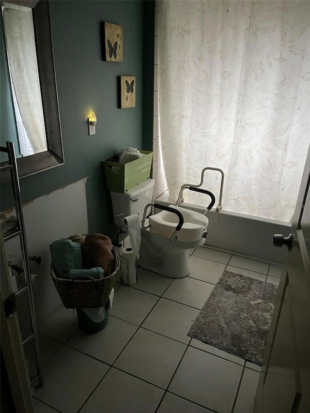 bathroom featuring tile patterned floors, shower / bathtub combination with curtain, and toilet