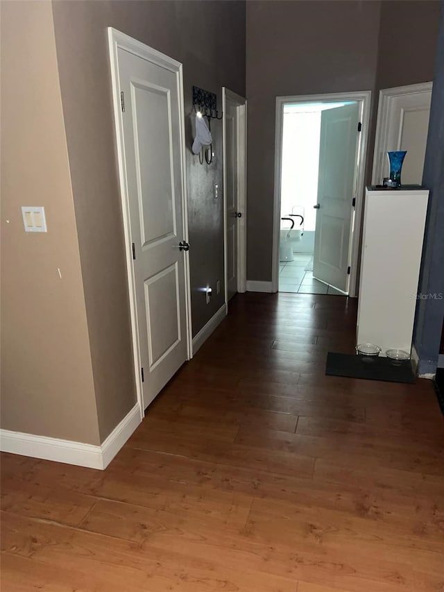 hallway with wood-type flooring and baseboards
