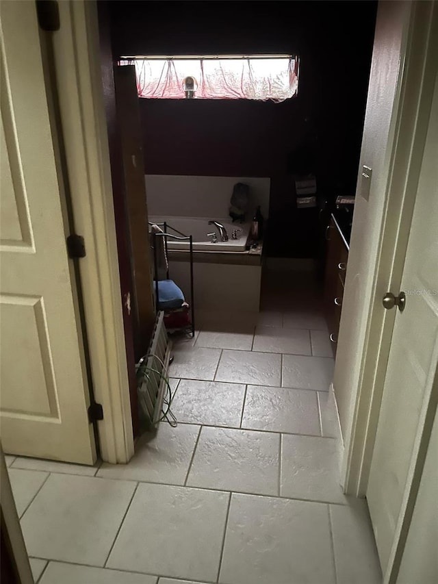bathroom with a garden tub and stone tile flooring