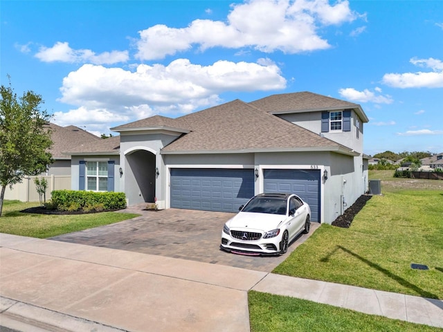 view of front of property with an attached garage, driveway, stucco siding, and a front lawn
