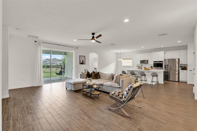 living room with visible vents, recessed lighting, a ceiling fan, and wood finished floors