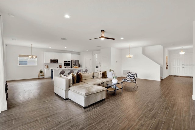 living room featuring visible vents, ceiling fan with notable chandelier, recessed lighting, and wood tiled floor
