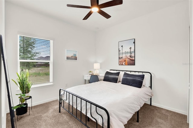 carpeted bedroom featuring baseboards and a ceiling fan