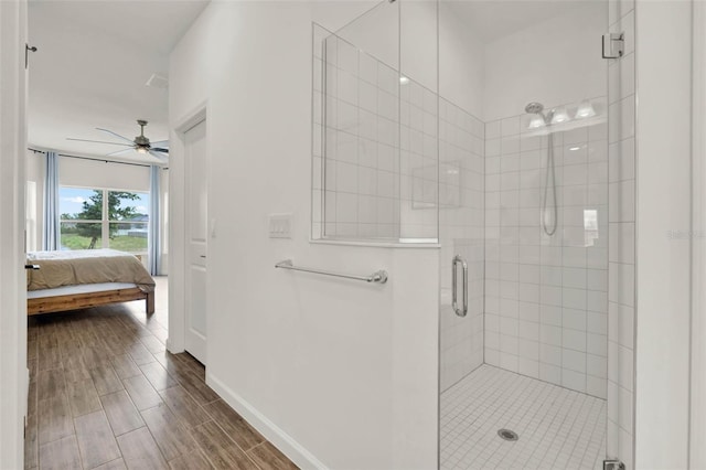 bathroom with baseboards, a stall shower, ensuite bath, wood tiled floor, and ceiling fan