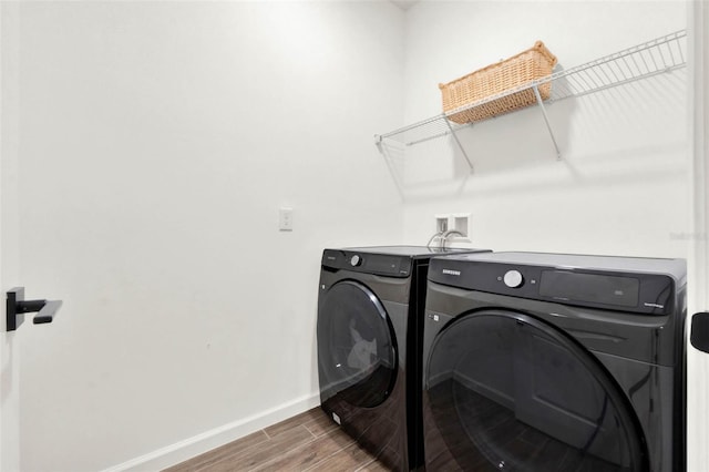 laundry area with washer and clothes dryer, baseboards, laundry area, and wood tiled floor
