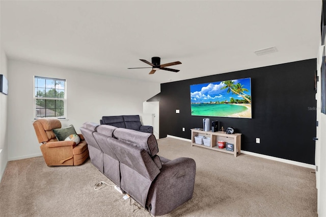 carpeted living room featuring an accent wall, baseboards, visible vents, and ceiling fan