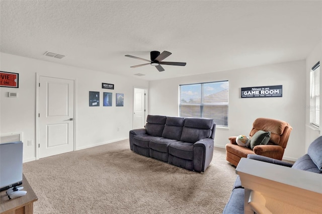 carpeted living room featuring a textured ceiling, baseboards, a ceiling fan, and visible vents